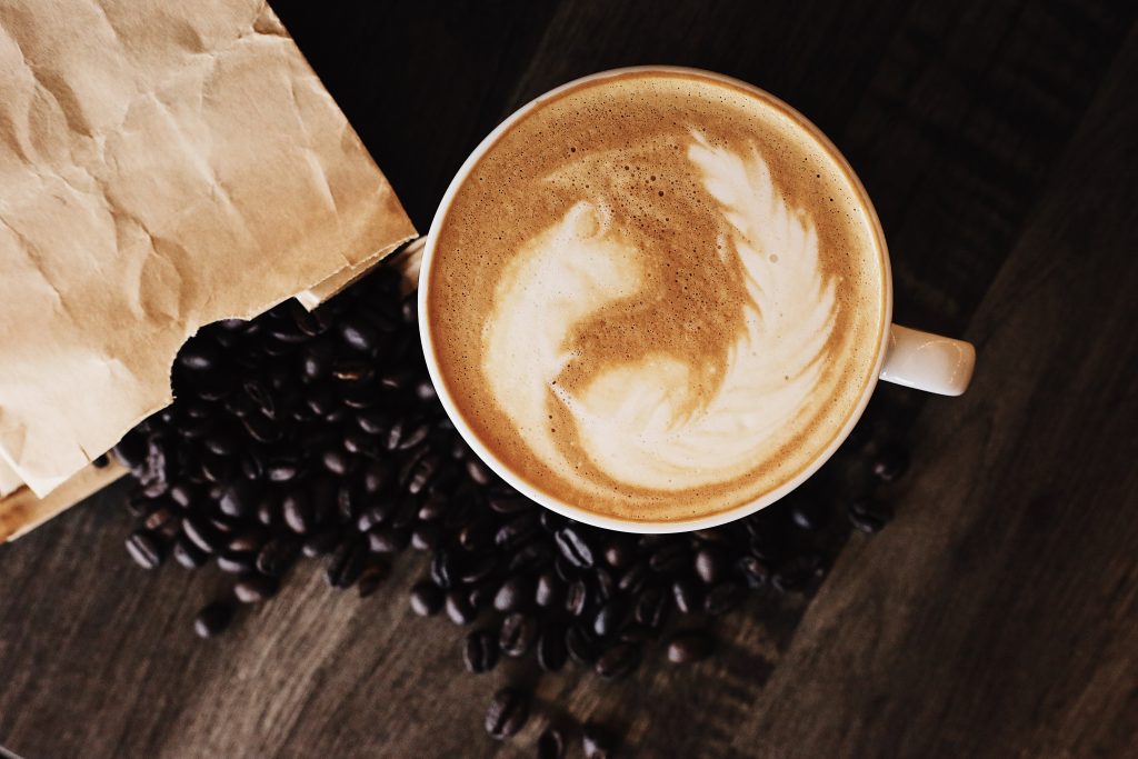 cup of coffee and coffee beans on an office table